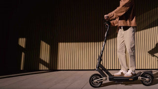 A man are riding Navee electric scooter.